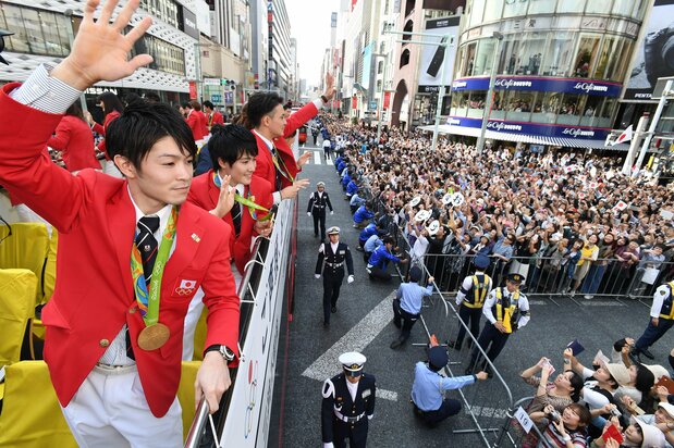 里约奥运会及残奥会日本代表团奖牌得主联合游行活动中，体操运动员内村航平等人向沿途群众挥手致意。2016年10月7日，东京银座（图片：时事社）