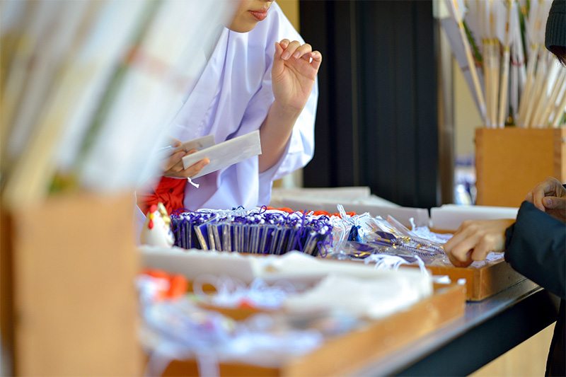 Différentes sortes de omamori au comptoir d’un sanctuaire (photo : Pixta)