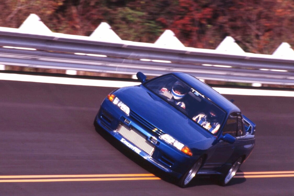 「谷田部」のバンクを駆け抜ける「TRUST GReddy RX」。パーツ開発車両兼デモカーとしてサーキットアタックやゼロヨンもこなした　写真：『Option』編集部