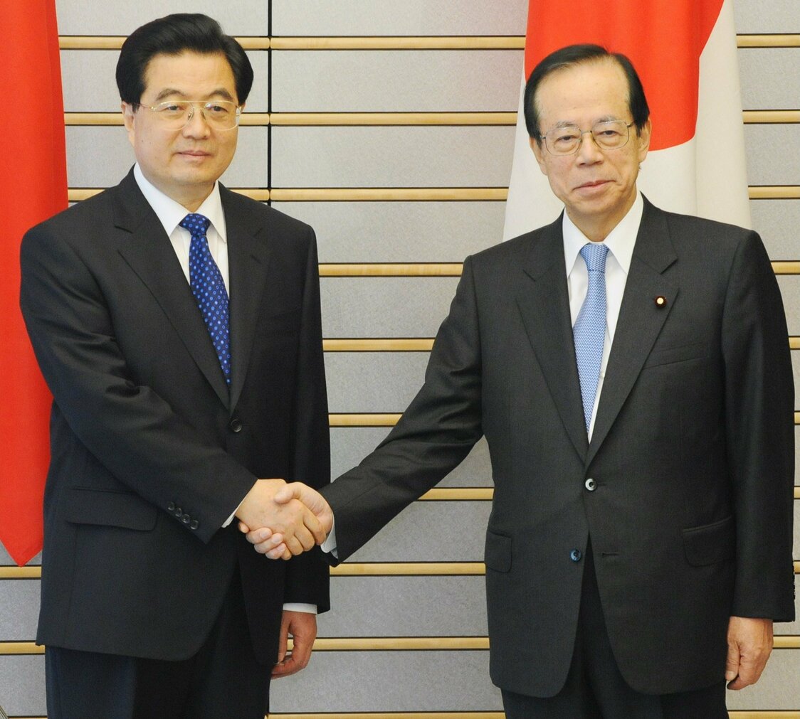 2008年5月7日、日中首脳会談を前に中国の胡錦濤国家主席（左）と握手する福田康夫首相（東京・首相官邸）=時事