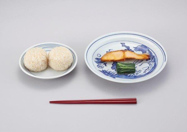 照片为明治22年(1889年)日本最初的学校供餐,菜品为饭团、咸鲑鱼和咸菜