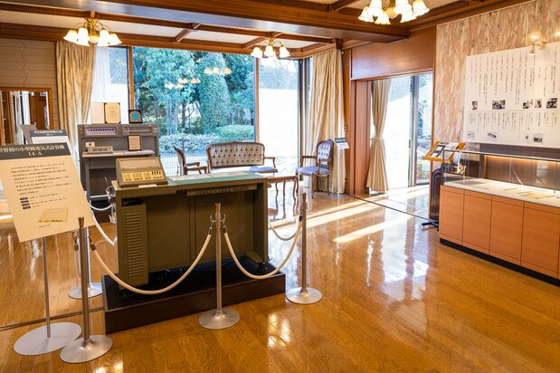 樫尾俊雄発明記念館に展示される14-A(中央)とAL-1(左奥)。机の背面にはリレー回路がびっしりと搭載されている
