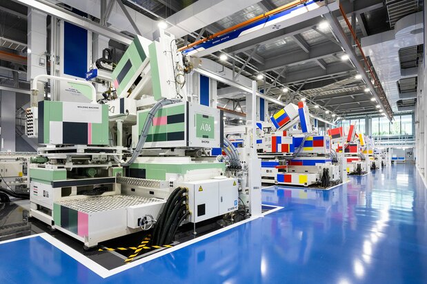 Bandai’s signature four-color injection molding machines. The one in the foreground is painted in hues reminiscent of the Zaku mobile suit and the one next to it recalls the White Base spaceship. (© Nippon.com)