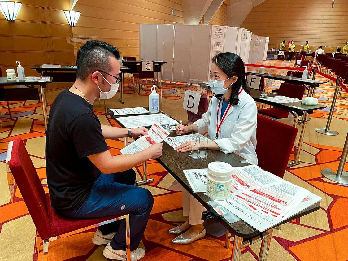 The author (right) conducts a pre-vaccination consultation.