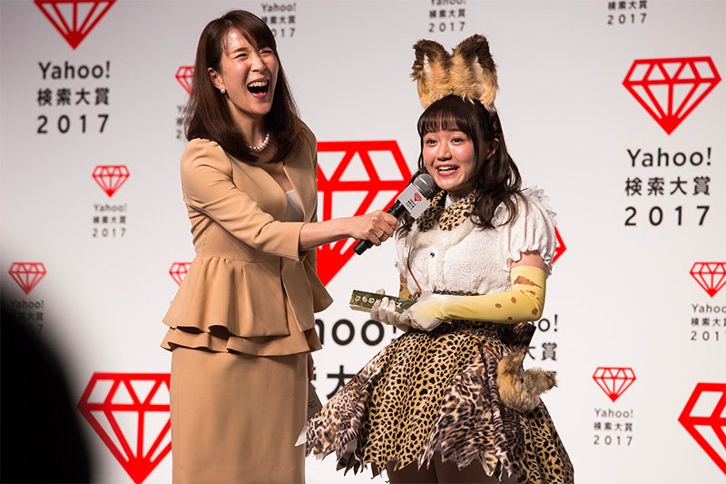 Kemono Friends voice actress Ozaki Yuka (right) speaks in the voice of Serval, her character, as she accepts the award for her anime title’s win.