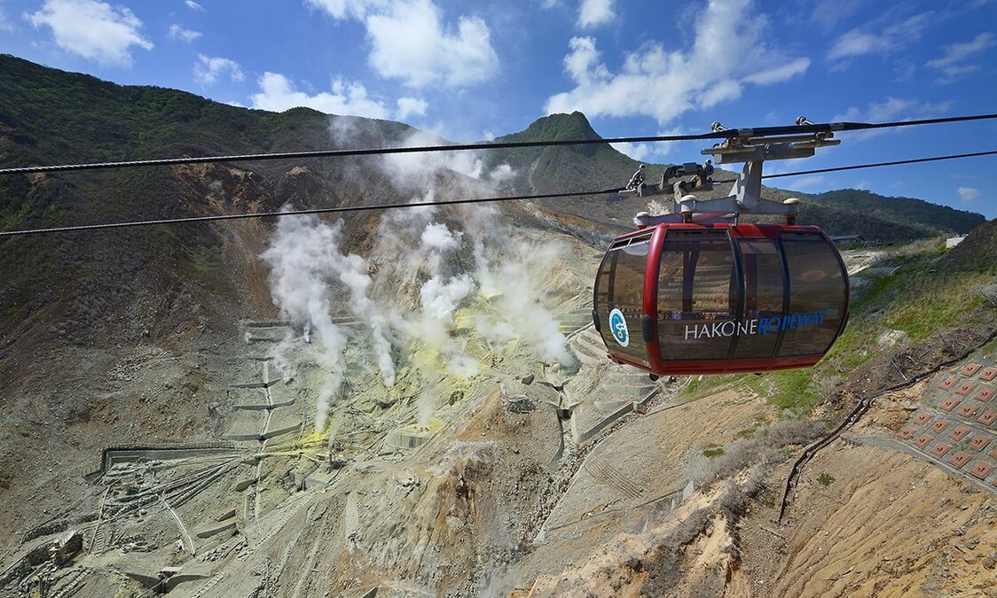 El teleférico Hakone Ropeway pasando por encima de Ōwakudani. Esta es una atracción popular entre los visitantes de la zona. (Fotografía cortesía de la Agencia Odakyū)