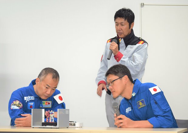 野口聰一和(前左)和金井宣茂(前右)在看將裝載在「G-SATELLITE 飛向宇宙」專案的人工衛星中的鋼彈模型,2019年9月4日,静岡市葵区(時事)