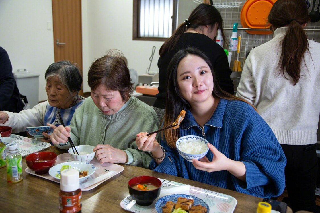 Taniguchi Karen (derecha), estudiante de la escuela de diseño donde enseña Ōkuma. Es una pasante fiable que se encarga del diseño del periódico para mujeres mayores y de la cafetería.