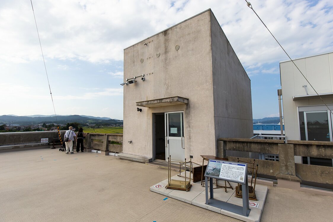 階段の塔屋前に散らばる5つの机が、避難時の緊迫した状況を伝える