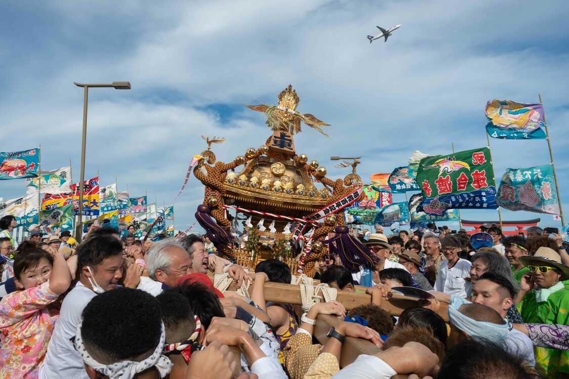 Gran Festival de Verano del Santuario de Haneda, celebrado anualmente. Los aviones surcan el cielo sobre las banderas de buena pesca que ondean al viento. (Fotografía de Hatsuzawa Ari)