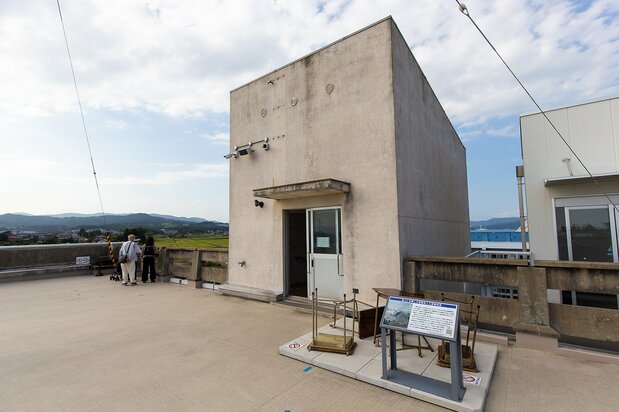 階段の塔屋前に散らばる5つの机が、避難時の緊迫した状況を伝える