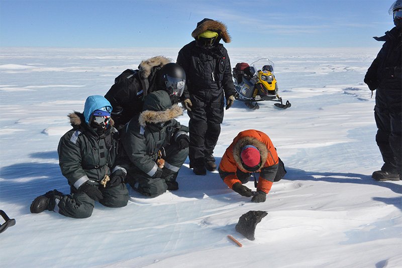 Des chercheurs observant des météorites dans la chaîne de montagnes des Sør Rondaneen en janvier 2013.