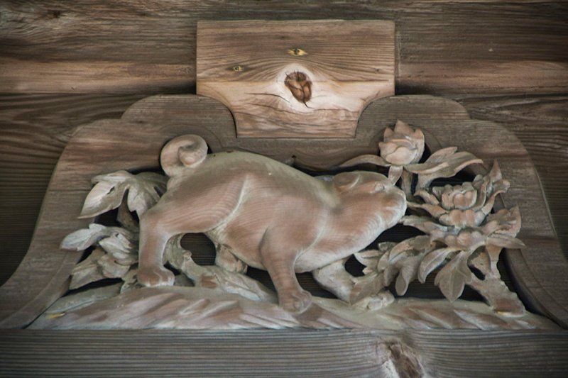 Le chien, une des sculptures ajourées des douze animaux du zodiaque ornant le dessous du toit