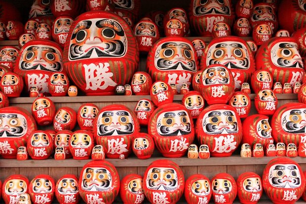 Les Daruma sont communément associés au proverbe « tomber sept fois, se relever huit », car un poids au niveau de leur base leur permet de se relever à chaque fois qu’ils se renversent.