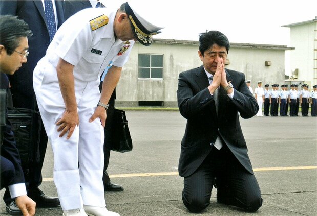戦死した多くの日本人兵士が眠る硫黄島の滑走路で突然、ひざまずき、合掌をした安倍首相(右)と河野統合幕僚長(左から2人目) 河野氏提供