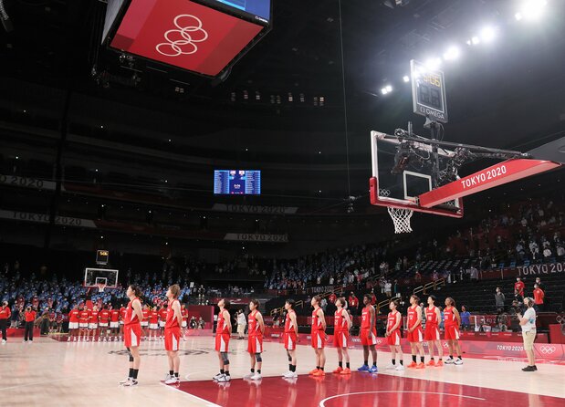 The Japanese women’s basketball team stands at attention during the opening of the final against the United States on August 8 at Saitama Super Arena. (© Jiji)