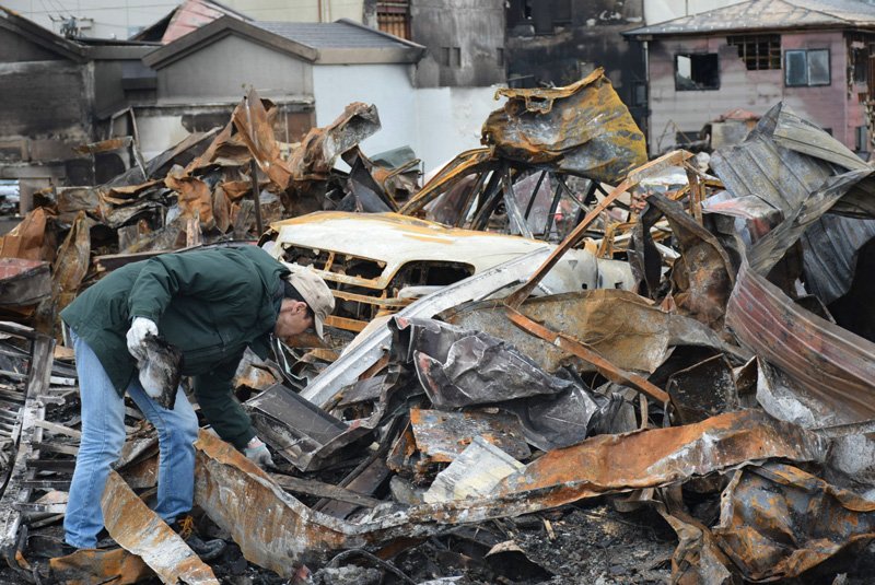 A man searches the wreckage of his home on December 26, 2016, following a major fire in Itoigawa, Niigata. (© Jiji)