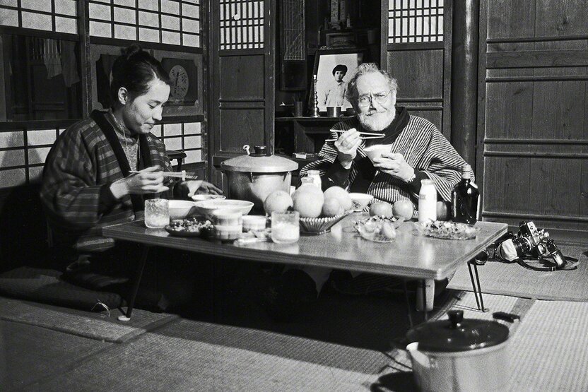 William Eugene Smith et son épouse Aileen Mioko Smith en train de dîner dans la salle de séjour de leur maison de Minamata. Ils portent l’un et l’autre la veste japonaise ouatée (dotera) utilisée traditionnellement par les Japonais en hiver. (Photo prise en 1972).