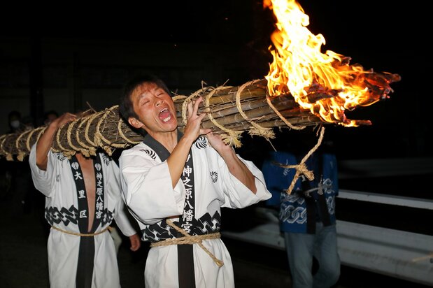 大きな松明を担いで宮入り