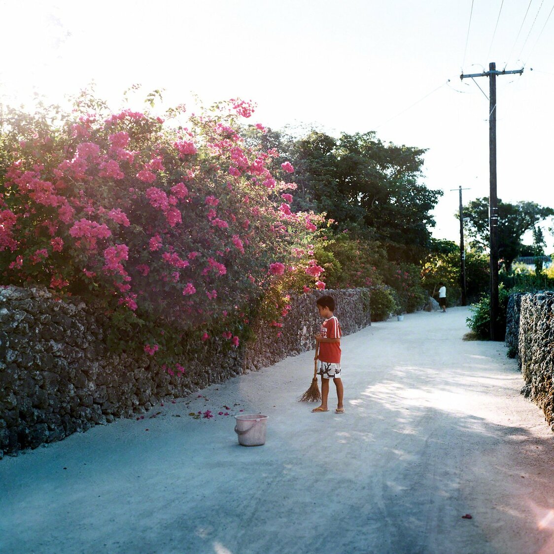Un niño barre el camino de arena blanca todas las mañanas (Taketomi)