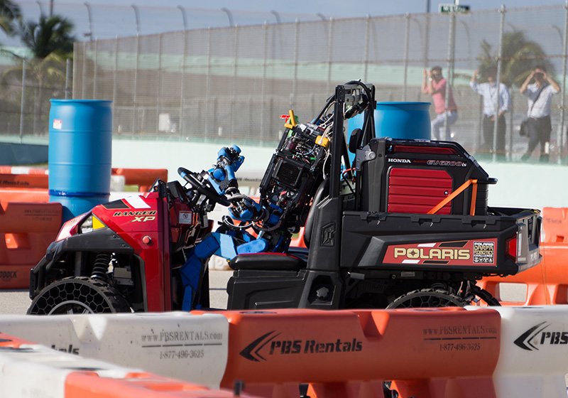 車を運転するシャフト社のロボット　©DARPA