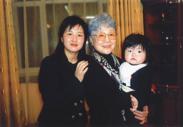 Sakie holding her great-grandchild in her arms. (Courtesy of Arita Yoshifu; © Jiji)