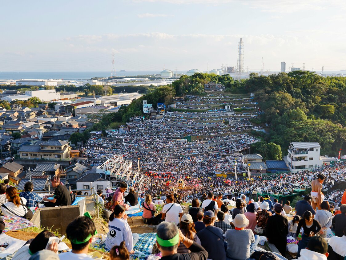Vistas del mar de Harima a lo lejos desde un lugar cercano a la cima del monte Otabi. Abajo se observan las carrozas efectuando el neriawase rodeadas del gentío. Solo los lugareños y los visitantes invitados pueden ocupar el palco para presenciar el acto, pero verlo desde los alrededores también resulta impresionante.