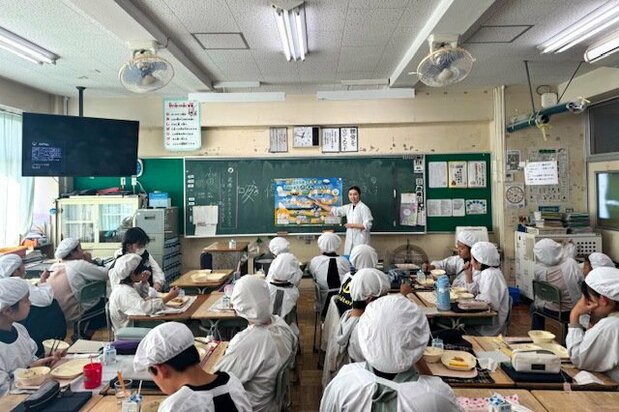 コメが生産され、米飯として給食に提供されるまでの過程を学ぶ子供たち(学校給食歴史館提供)