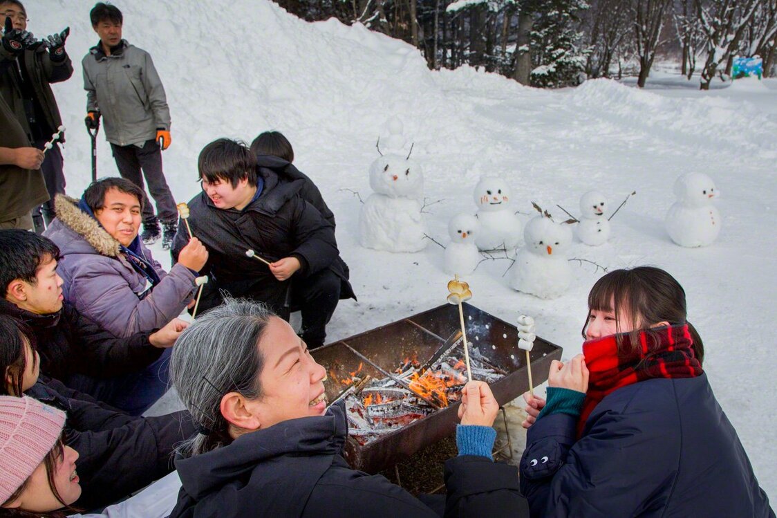 Alumnos del Sureste Asiático pasándolo en grande haciendo muñecos de nieve y asando nubes de golosina.