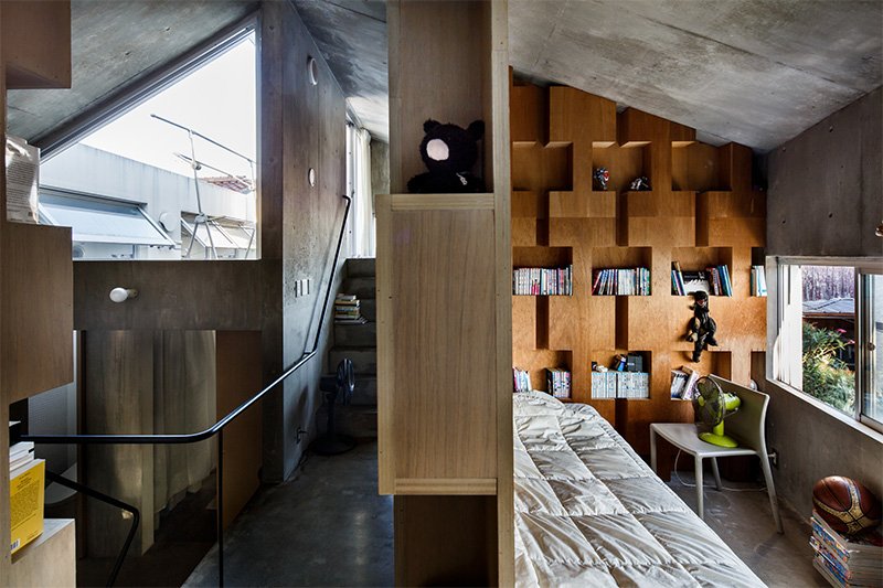 Bedrooms upstairs are separated by bookshelves.