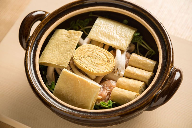 Ingredientes en la olla antes de verter el caldo dashi. Antes de ponerla al fuego, se coloca encima un trozo grande de yuba.