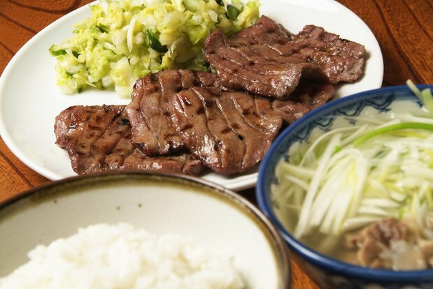 Langue de bœuf grillée, servie avec du riz à l'orge et une soupe de queue de bœuf.