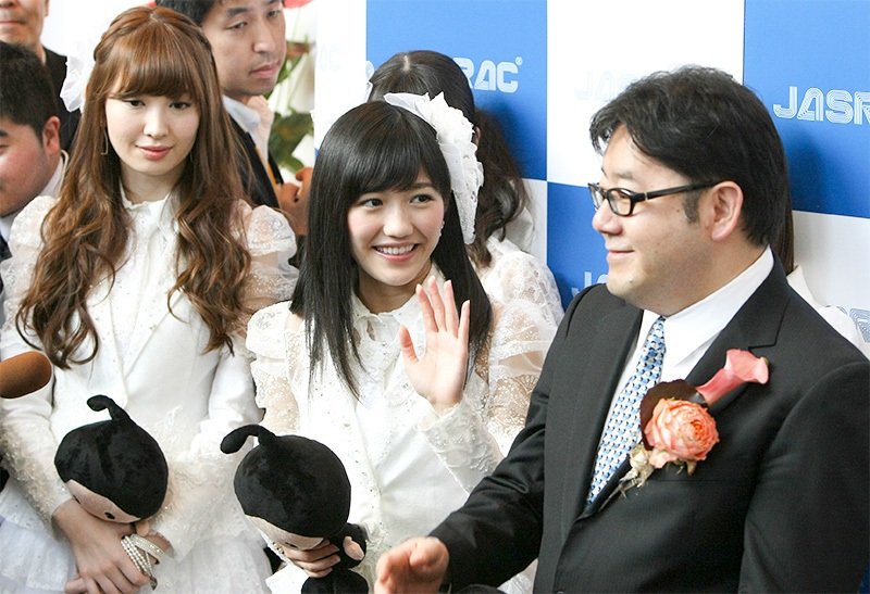 أكيموتو ياسوشي مع أعضاء AKB48 في حفل توزيع جوائز JASRAC الحادي والثلاثين في 22 مايو/ آيار 2013. الصورة من جيجي برس.