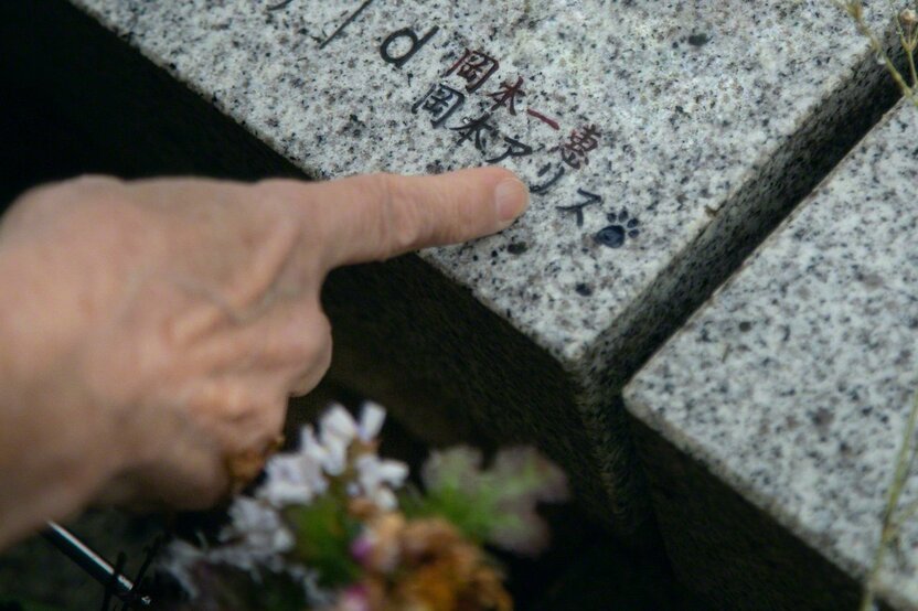 長者指著自己名字下方刻著的愛貓名字——岡本愛麗絲。