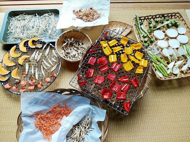 Las verduras se pueden secar en el interior. Arriba, empezando por la izquierda, seta de aguja y un combinado de zanahoria y rábano japonés. En el medio, empezando por la izquierda, calabaza, zanahoria y bardana y, en sendos recipientes, seta shimeji y jengibre de myōga. Abajo, empezando por la izquierda y en orden ascendente, zanahoria y bardana, pimiento rojo y amarillo y quimbombó y nabo kabu en rodajas y tiras.