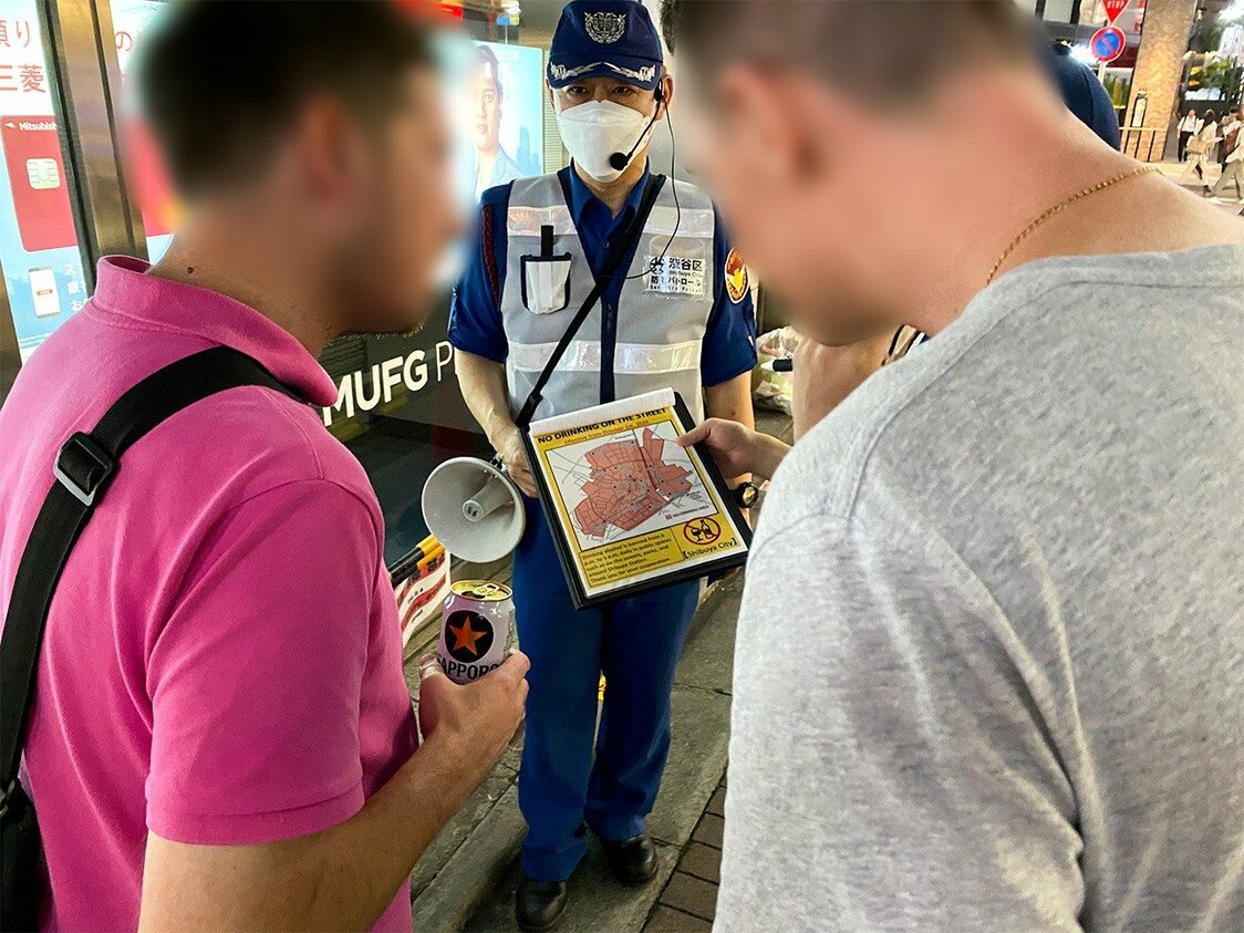 Deux étrangers qui ne veulent pas lâcher leur canette de bière même après qu’une patrouille leur a expliqué l’interdiction de boire dans la rue, près de la gare JR Shibuya, le 4 octobre 2024. (Avec l’aimable autorisation de l’auteur)