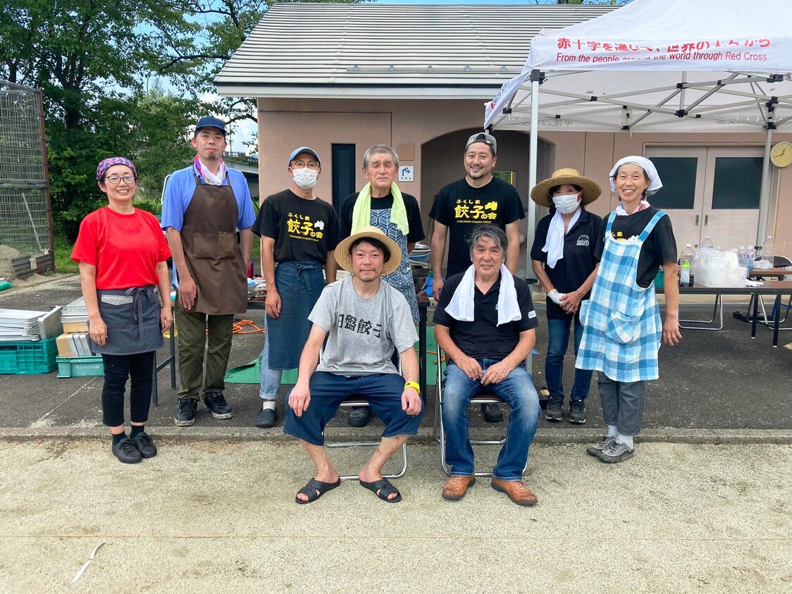 Tsukahara Hitoshi (devant à gauche), propriétaire du restaurant chinois Bokuten et président du Fukushima Gyôza Group, en compagnie d’autres membres lors d’un événement promotionnel. (© Fukushima Gyôza Group)