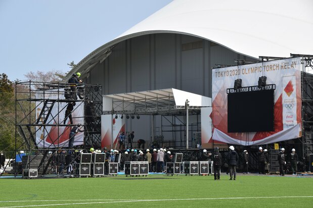 東京五輪聖火リレーの延期を受け、式典のステージの撤収作業が行われているサッカー施設「Jヴィレッジ」=2020年3月26日、福島県楢葉町(時事)