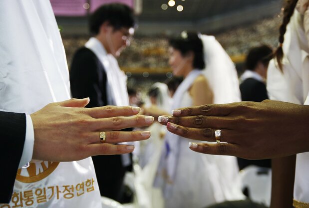 Couples marry in a mass wedding put on by the Unification Church. (© Reuters)