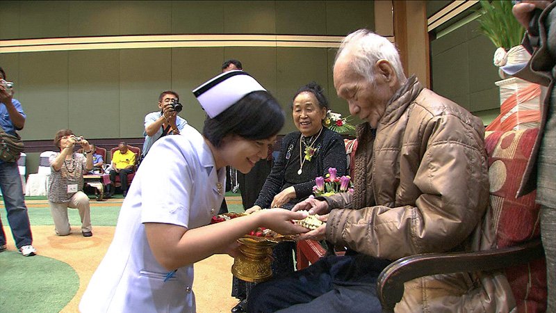 クワイ河平和基金の奨学金授与式で、元奨学生から贈り物を手渡される永瀬さん（右）