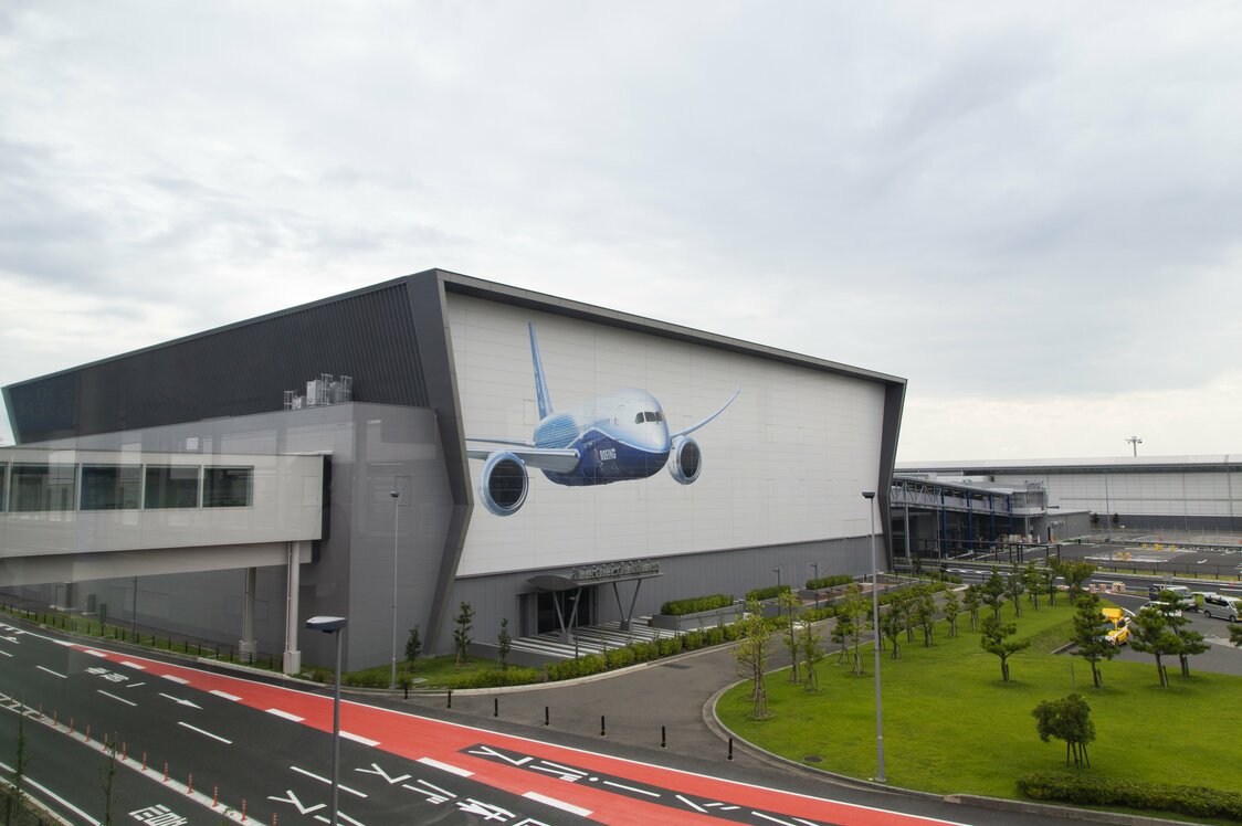 ボーイング787が描かれた建物がフライト・オブ・ドリームズ。建物の3階を連絡デッキが通過する。右奥に連結するのが第2ターミナル