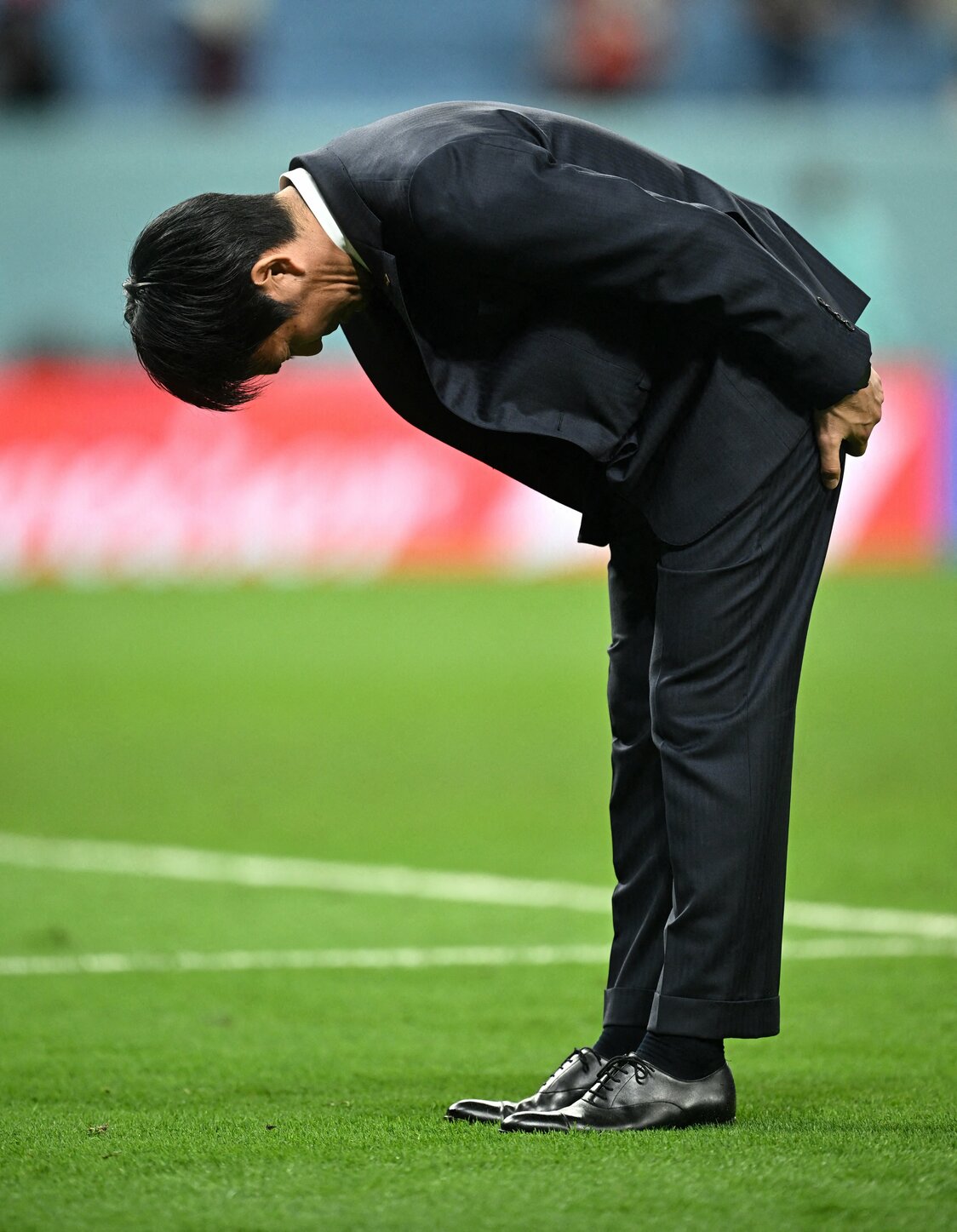 サッカーW杯カタール大会決勝トーナメントで敗退し、スタンドのサポーターに深々とお辞儀をする森保一監督＝2022年12月5日（ロイター）