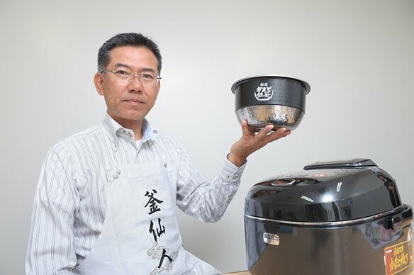 M. Morimichi tenant en main le « kama » qui lui tient à cœur. Il participe à de nombreux événements avec son tablier fétiche, marqué «Kama Sennin ».