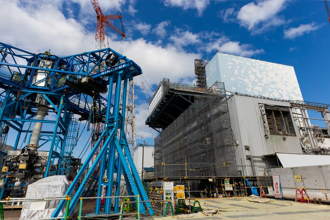 右は2号機の原子炉建屋。手前は排気塔を切断するための重機