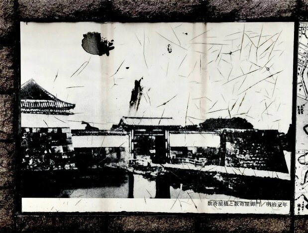 Une vieille photographie datée de la première année de l’ère Meiji, incrustée dans la chaussée de Harumi-dôri, montre le pont de Sukiya-bashi et sa porte fortifiée. (Photo prise par l’auteur)