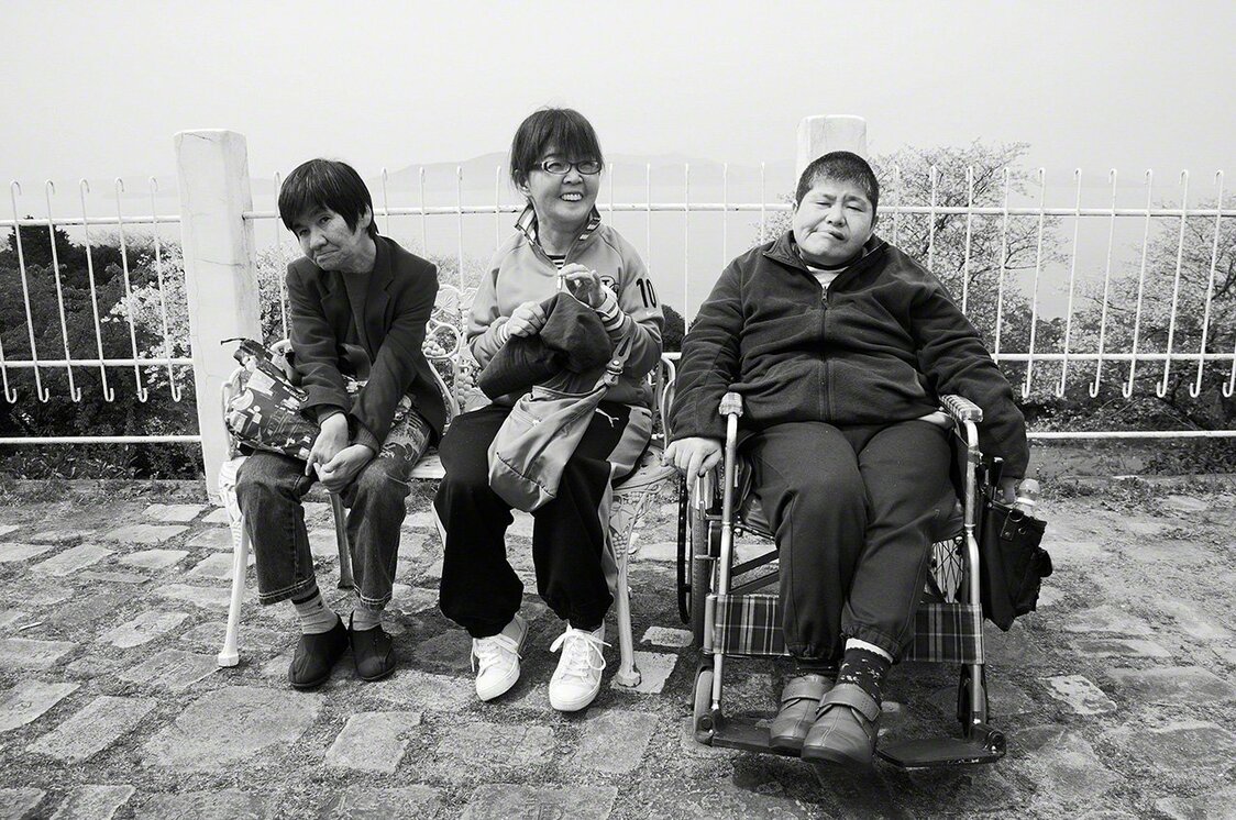 Les trois amies d’enfance victimes de la maladie Minamata, 40 ans plus tard. Sakamoto Shinobu est à gauche. Maeda Emiko (au centre) est morte en 2018 et Kagata Kiyoko (à droite) ne se déplace plus qu’en fauteuil roulant. (Photo prise en 2012, dans le parc Yunoko de Minamata)