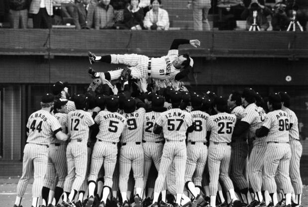 L’entraineur Yoshida Yoshio (au centre), porté en triomphe par les joueurs des Hanshin après avoir remporté la victoire contre Seibu et décroché le titre de champion du Japon, le 2 novembre 1985, au stade Seibu. (Jiji)