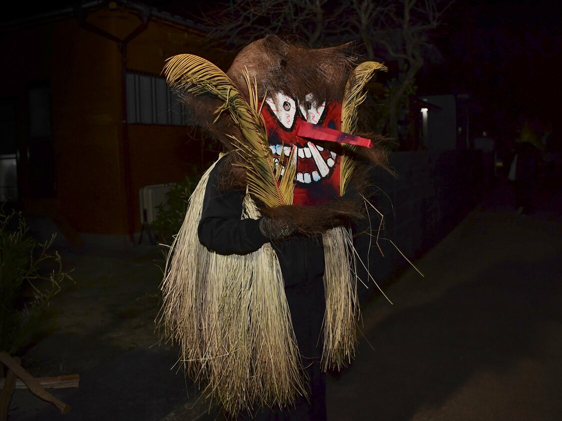 子どものいる家に向かって、夜道を移動するトシドン。髪の毛部分はシュロの皮で、たてがみのように顔の左右に飾られるのがソテツの葉