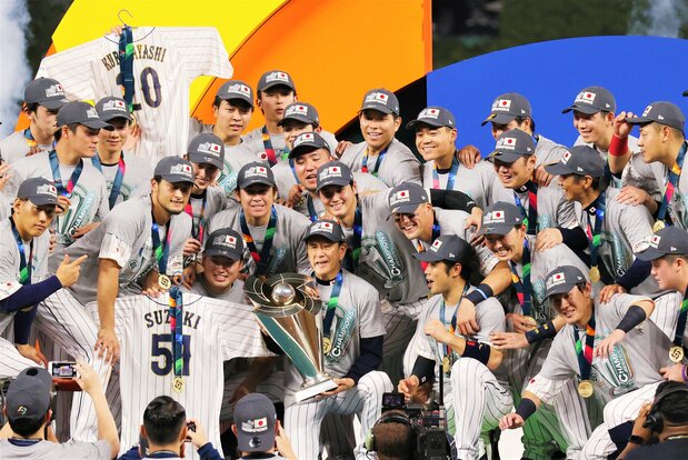 WBCで3回目の優勝トロフィーを手にし、栗山監督を中心に記念撮影に臨む日本代表の選手ら=2023年3月21日、米フロリダ・ローンデポパーク(時事)