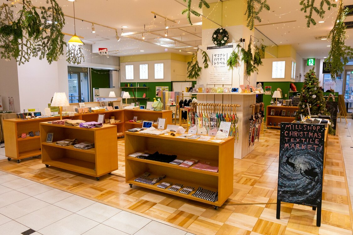 تتوفر العناصر الصغيرة من المنسوجات المحلية في متجر ياماناشي وايفينج ترافيل ميل ”Yamanashi Weaving Travel Mill Shop“ داخل مركز التسوق كيو ستا ”Q-Sta“ بجوار محطة فوجي يوشيدا.